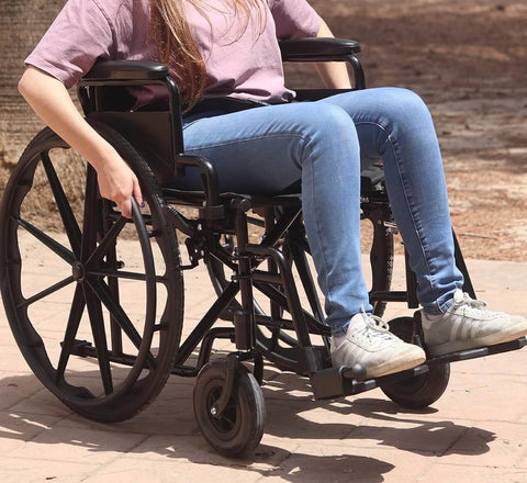 Person in a wheelchair on a paved surface with a blurred background