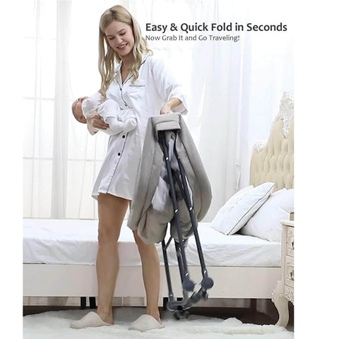 Woman holding a baby and folding a travel cot in a bedroom setting